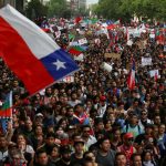 Demonstrators march with flags and signs during a protest against Chile's state economic model in Santiago, Chile October 25, 2019. 
